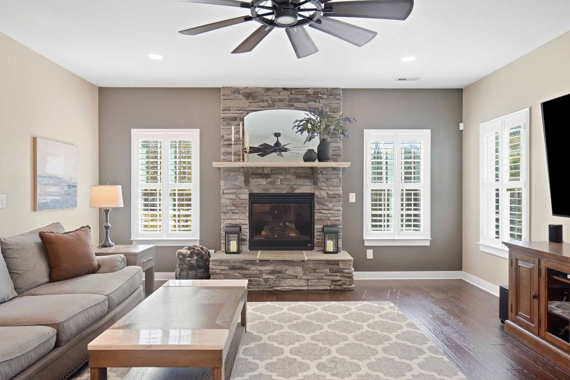 Family room with stone fireplace and plantation shutters at 912 Manorwood Drive Waxhaw NC